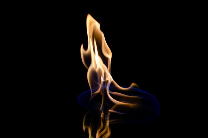 Mesmerizing image of a dancing flame against a black backdrop.